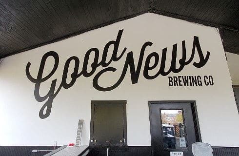 Large white wall with black logo lettering for a brewing company