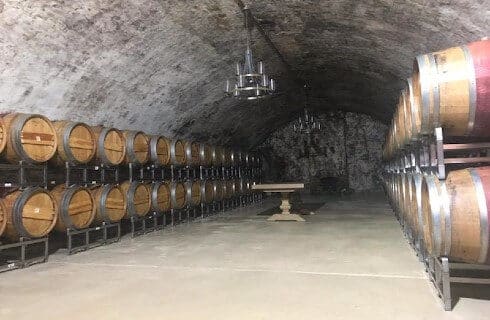 Rows of barrels stacked on each other in a cavernous wine cellar