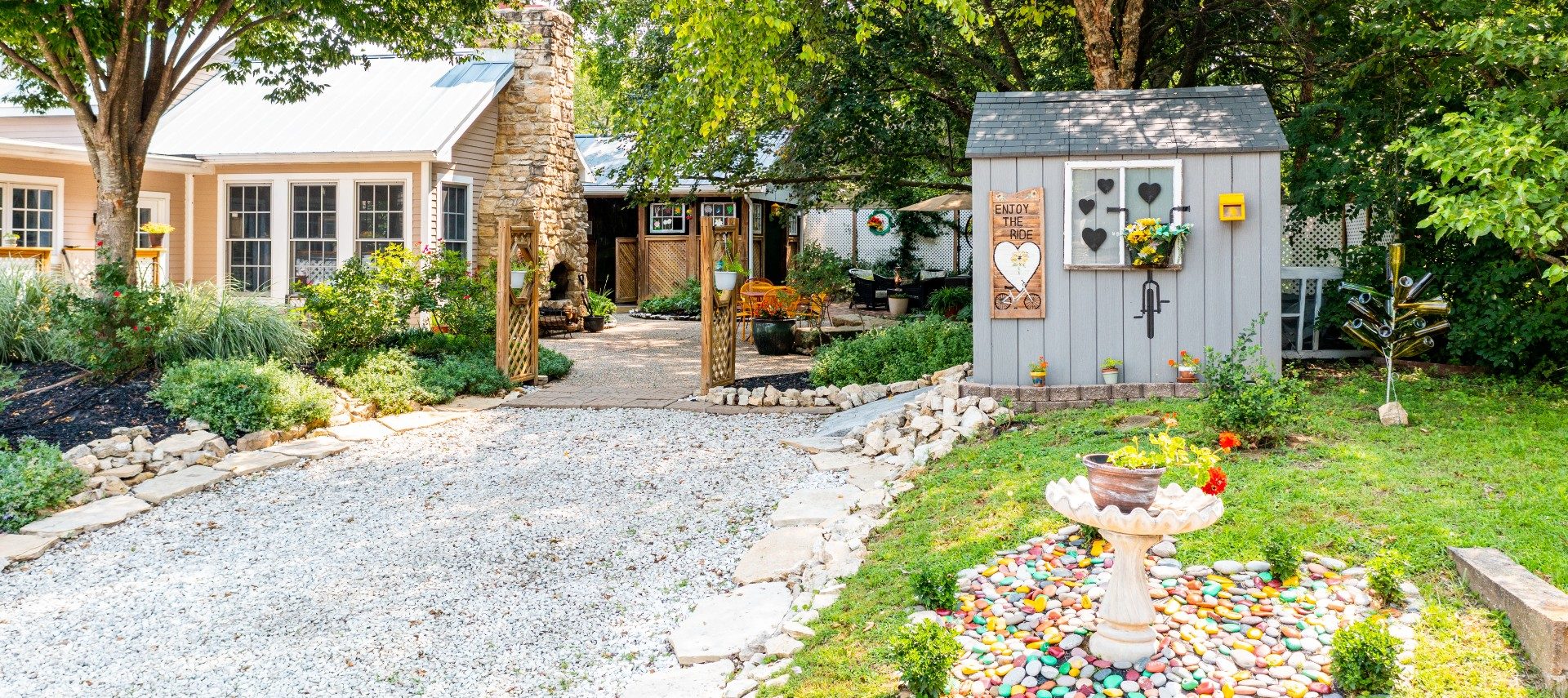 Side driveway of a home leading to a grey shed and large outdoor patio