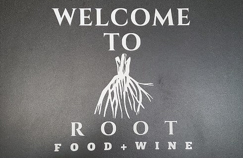 Black and white logo with text and a drawing of a root